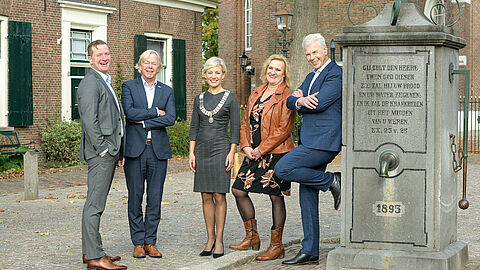 Foto waarop het het college staat bij de pomp in Langbroek: van links naar rechts: Jeroen Brouwwer, Jan Kuiper, Iris Meerts, Wil Kosterman en Hans Buijtelaar